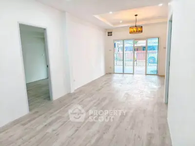 Spacious open-plan living room with modern flooring and large windows