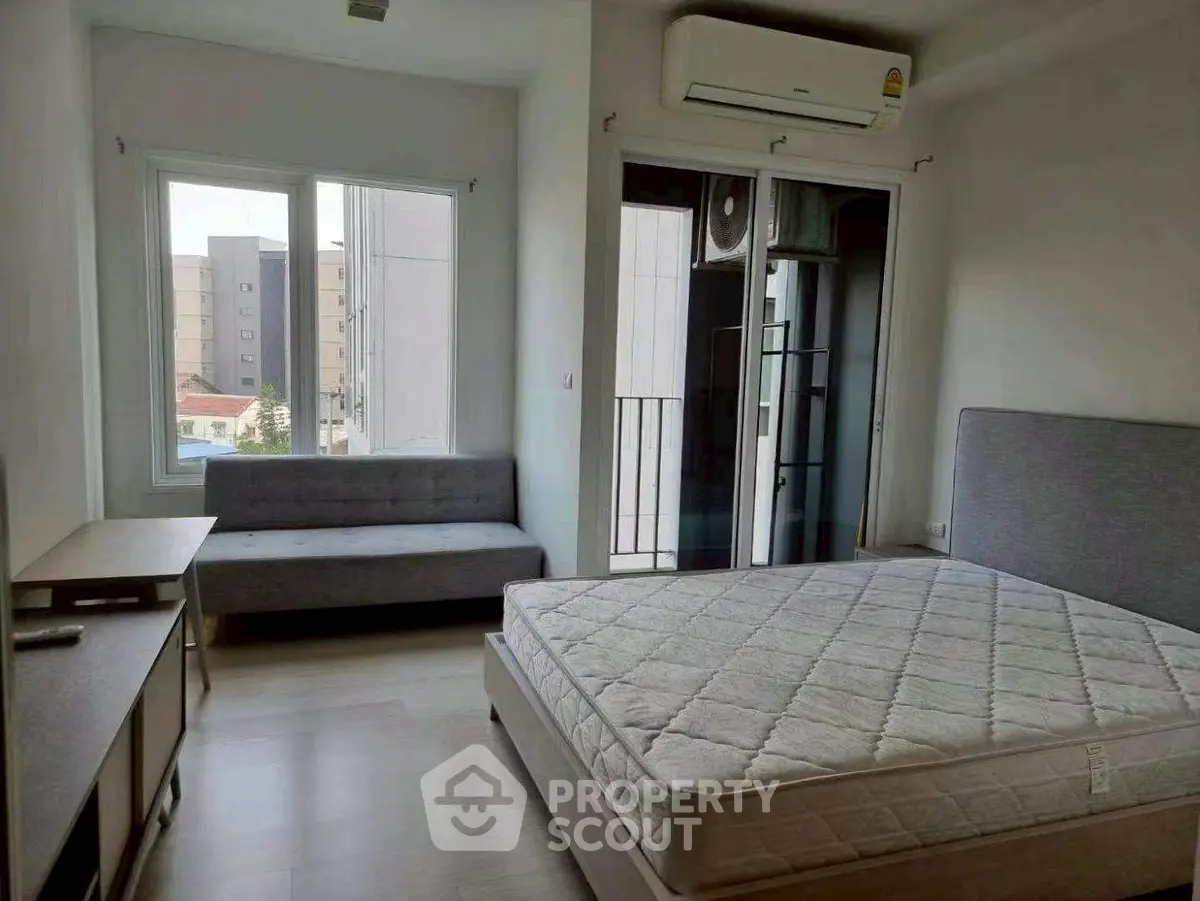 Spacious bedroom with modern furnishings and natural light in urban apartment