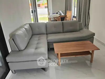 Modern living room with gray sectional sofa and wooden coffee table, bright and inviting space.