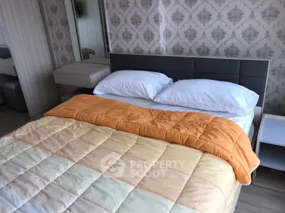 Cozy bedroom with elegant wallpaper and modern furnishings.