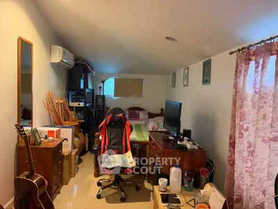 Cozy bedroom with gaming chair, guitar, and floral curtains