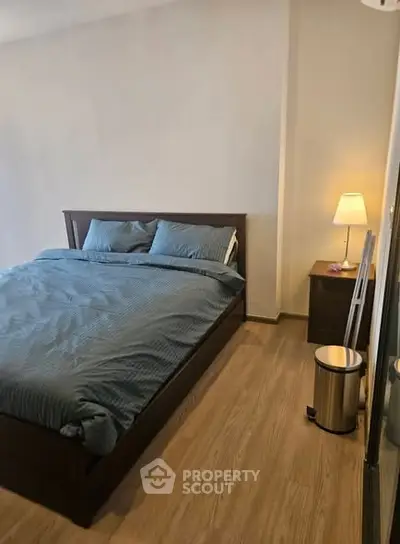 Cozy bedroom with wooden flooring and modern furnishings, perfect for relaxation.