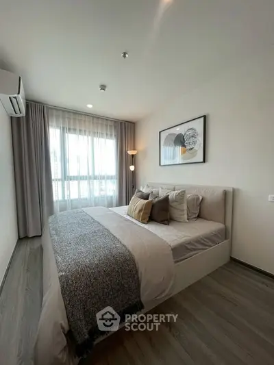 Modern bedroom with stylish decor and large window in a contemporary apartment.