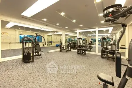 Spacious modern gym with state-of-the-art equipment in luxury residential building.