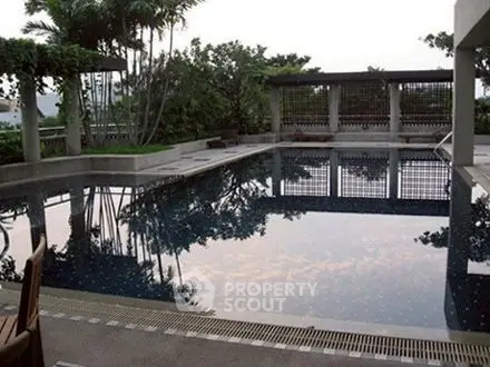 Luxurious outdoor pool with lush greenery and elegant design, perfect for relaxation and entertainment.