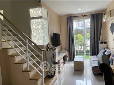 Modern living room with staircase and garden view, featuring stylish decor and natural light.