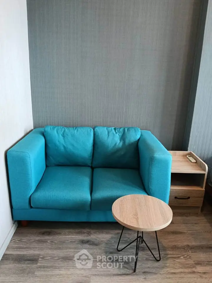 Cozy living room corner with a blue sofa and modern side table