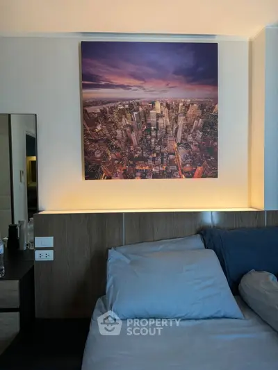 Modern bedroom with cityscape artwork and cozy bedding