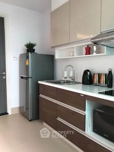 Modern kitchen with sleek cabinetry and stainless steel appliances in a stylish apartment.