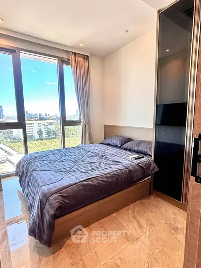Modern bedroom with large windows offering stunning city views and natural light.