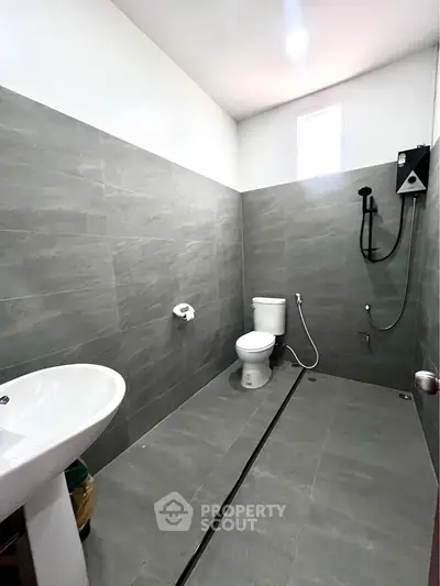 Modern minimalist bathroom with sleek gray tiles and open shower design.