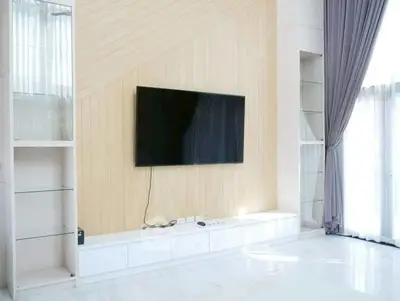 Modern living room with sleek TV setup and elegant curtains
