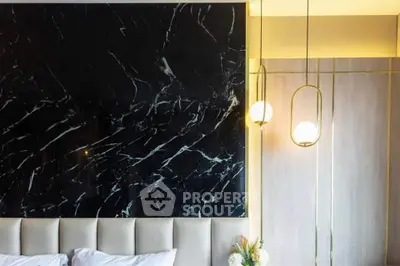 Luxurious bedroom with elegant marble accent wall and modern lighting