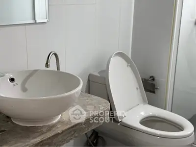 Modern bathroom with sleek fixtures and elegant design, featuring a stylish sink and toilet.