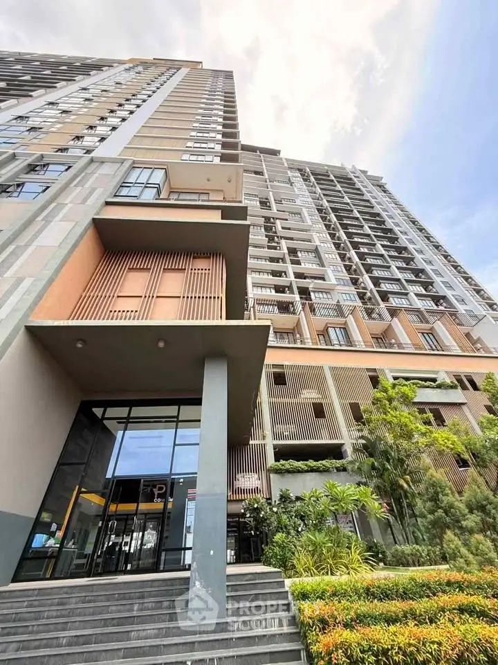 Modern high-rise building with lush landscaping and sleek entrance