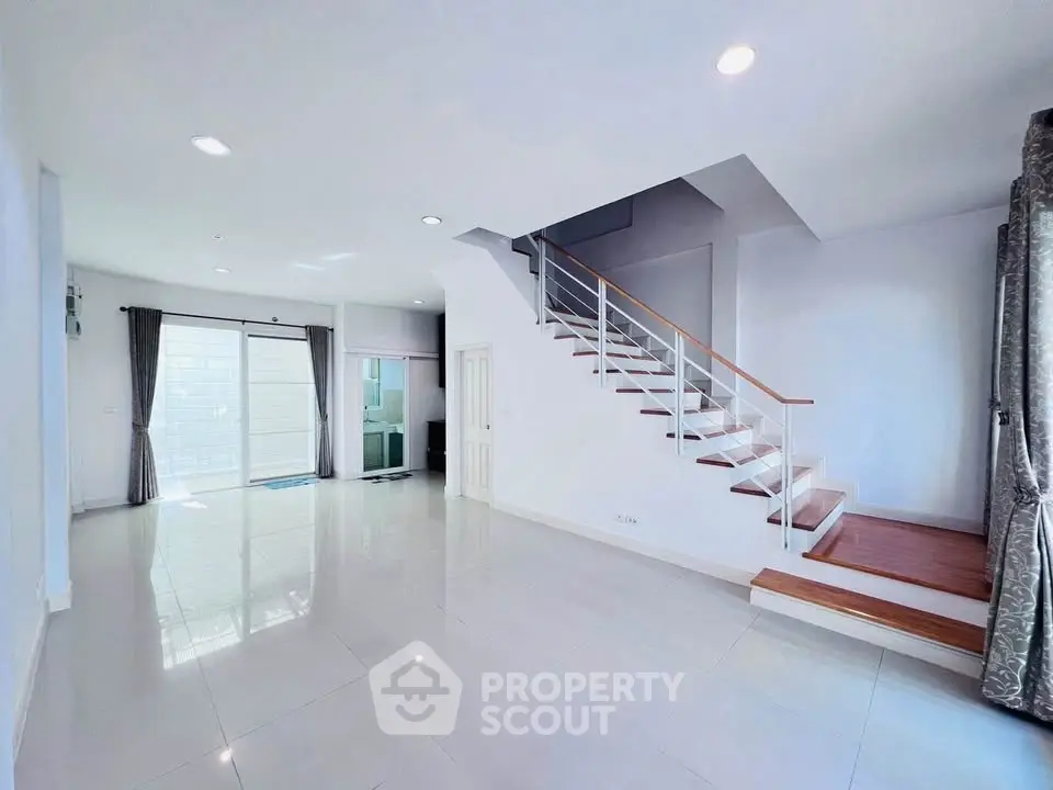 Spacious modern living room with staircase and large windows
