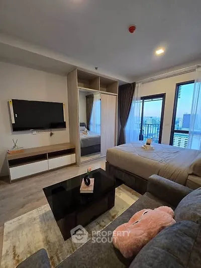 Modern bedroom with city view, featuring stylish furniture and large windows for natural light.