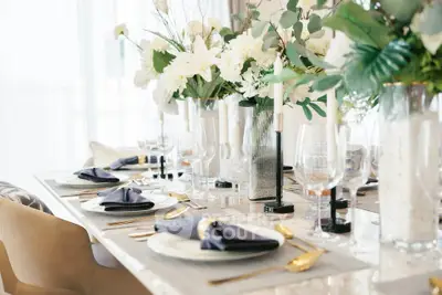 Elegant dining table setup with luxurious decor and floral arrangements in a modern home.