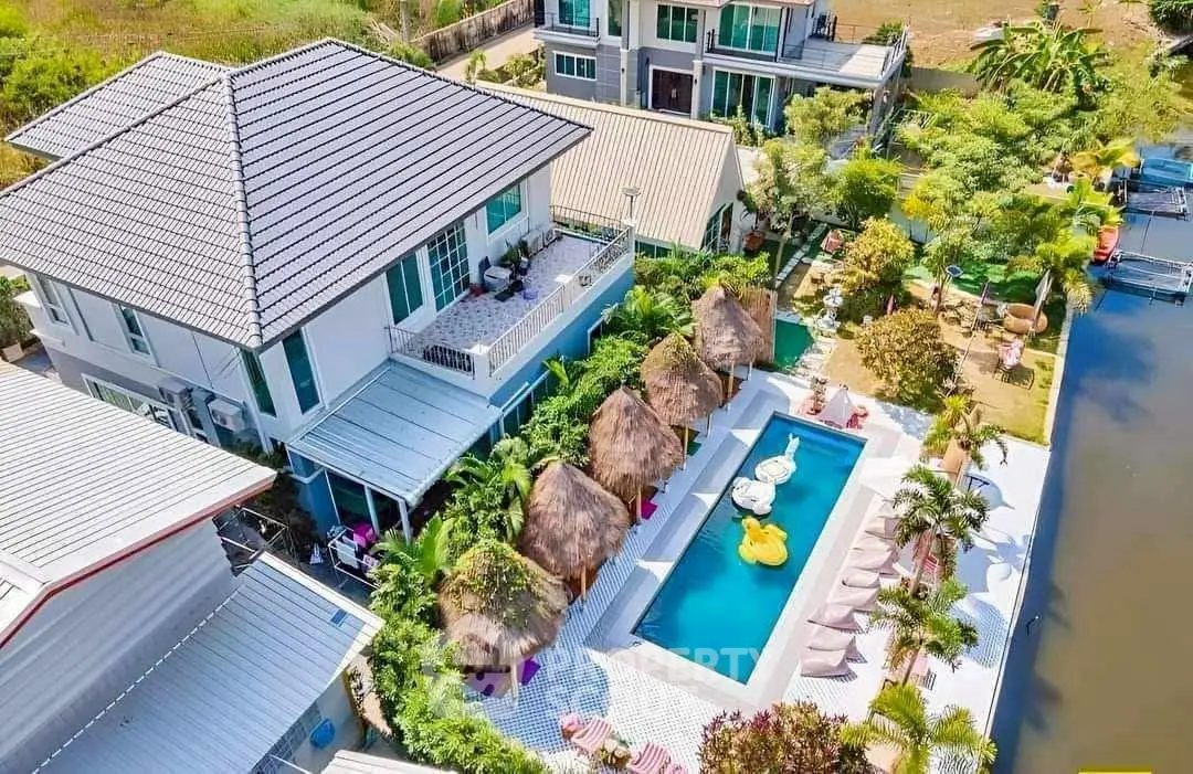 Luxurious riverside villa with private pool and lush garden, perfect for serene living and entertaining.