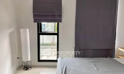 Modern bedroom with sleek design and natural light through large window.