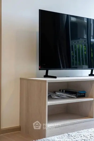 Modern living room with sleek TV stand and large flat-screen TV