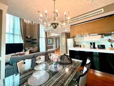 Luxurious open-plan living room with elegant chandelier and modern kitchen
