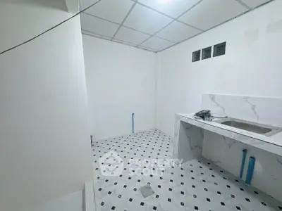 Spacious kitchen area with modern tiled flooring and marble countertop