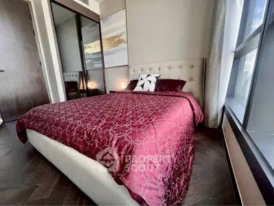 Luxurious bedroom with elegant decor and large window offering natural light.