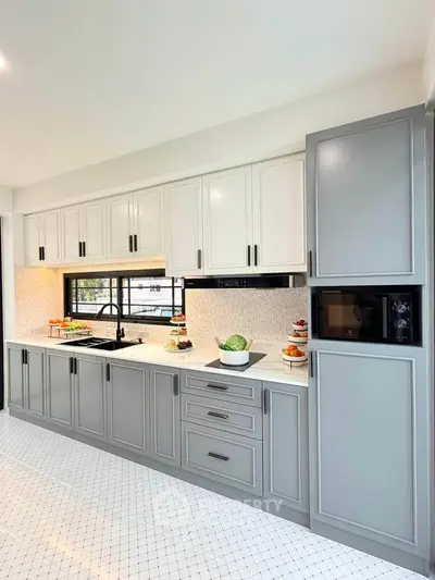 Modern kitchen with sleek cabinetry and built-in appliances, featuring a stylish open layout and elegant design.