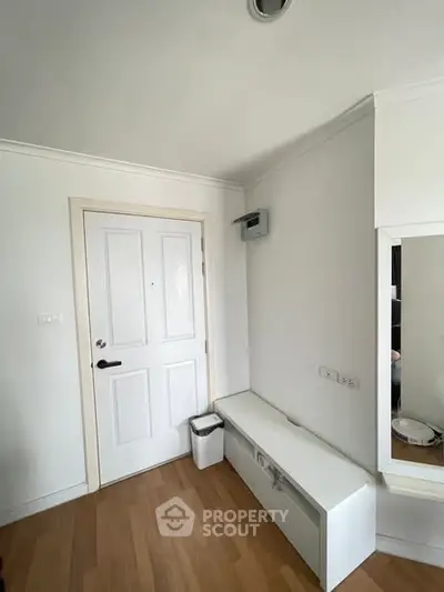 Modern entryway with white door and sleek storage bench in a minimalist interior design.