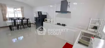 Spacious kitchen with dining area, featuring modern appliances and sleek design.