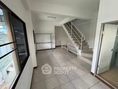 Spacious interior with tiled flooring and staircase, ideal for versatile use in a modern property.
