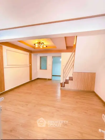 Spacious living room with modern lighting and wooden flooring in a stylish home.