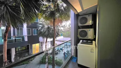 Charming balcony with lush greenery and modern appliances, perfect for urban living.