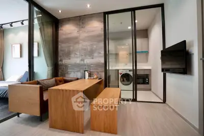 Modern living room with wooden furniture and glass partition to laundry area.