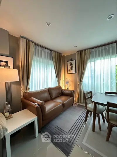 Cozy living room with leather sofa, dining area, and elegant curtains.