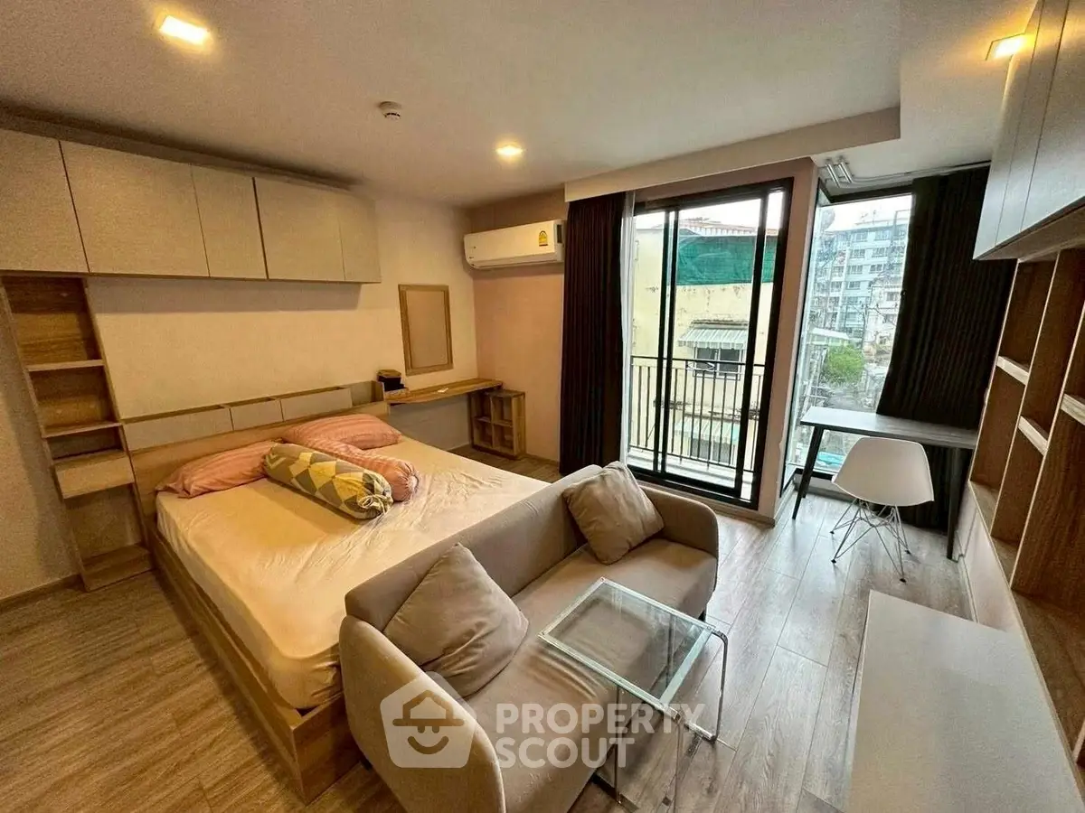Modern bedroom with balcony and stylish furniture in urban apartment
