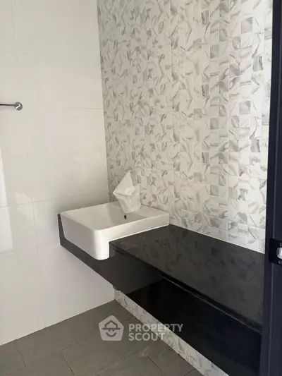 Modern bathroom with sleek black countertop and stylish tile design