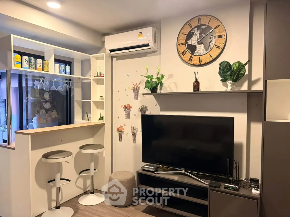 Modern living room with stylish decor, wall clock, and entertainment setup in cozy apartment.