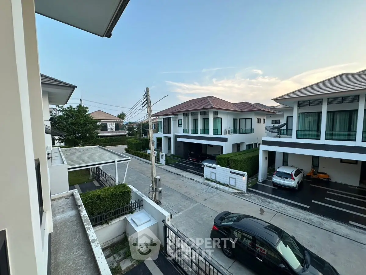 Modern suburban neighborhood with stylish two-story houses and parked cars.