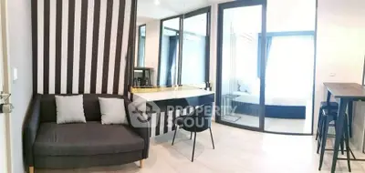 Modern living room with stylish decor and glass partition in contemporary apartment.