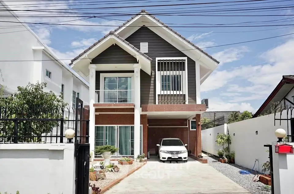 Charming two-story house with driveway and car, featuring modern architectural design.