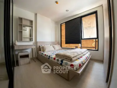 Cozy bedroom with modern decor and large window for natural light.