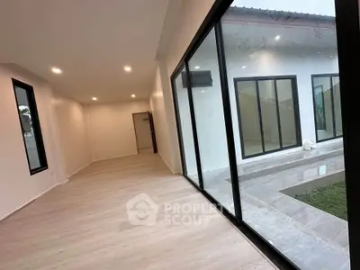 Spacious modern room with large windows and sleek flooring, perfect for natural light lovers.