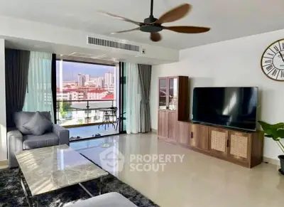 Spacious living room with modern decor and balcony view in a high-rise apartment.