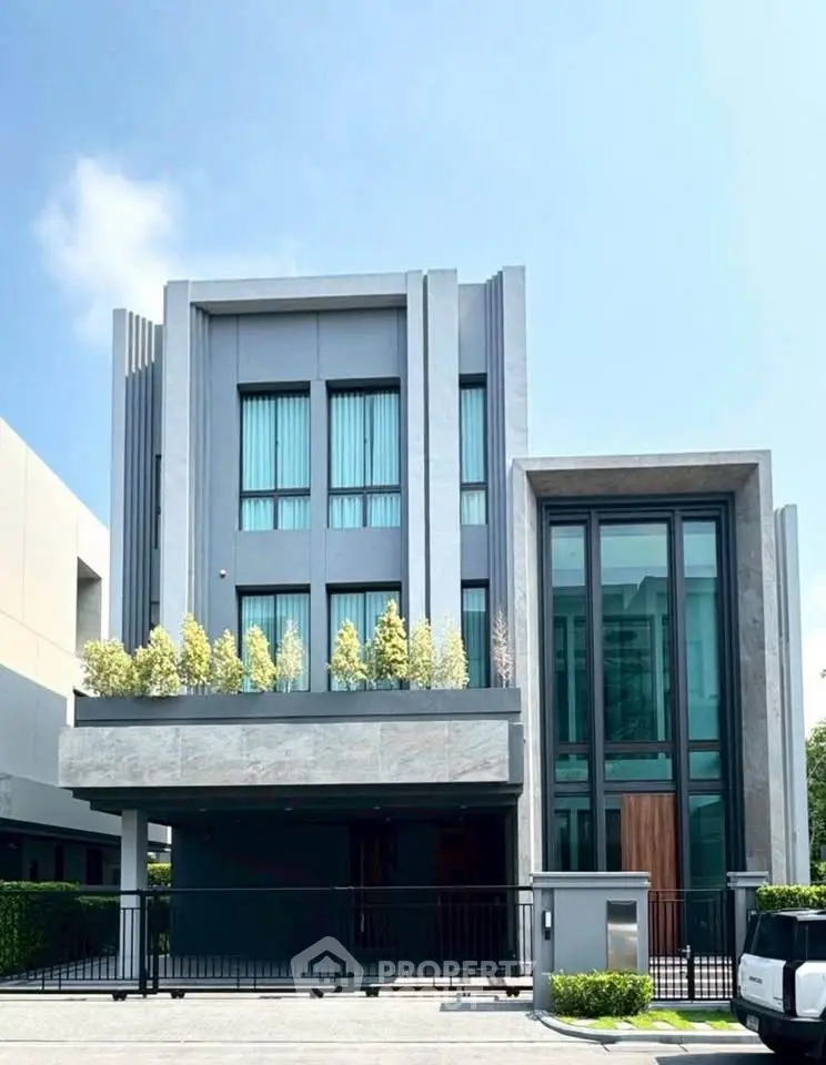 Modern luxury house with sleek design and large windows, featuring a stylish facade and lush greenery.