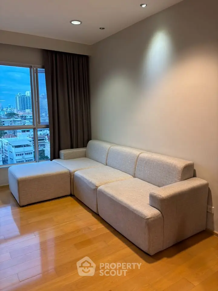 Modern living room with city view and stylish beige sofa