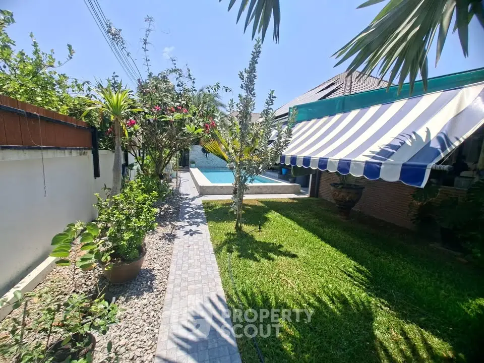 Charming garden with lush greenery and poolside view, perfect for relaxation and outdoor enjoyment.