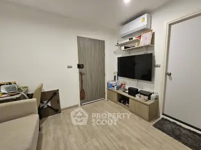 Modern living room with air conditioning and wall-mounted TV in cozy apartment.