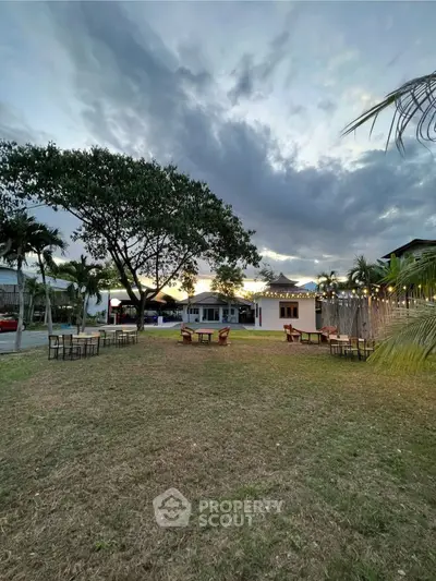 Charming garden view with outdoor seating and lush greenery at sunset.